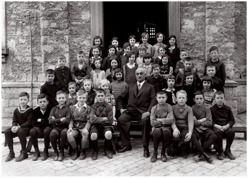 Ludwig Langstädter ca. 1930 mit einer Klasse (Jahrgang 1921) vor dem Eingang der heutigen Präsident-Mohr-Schule Quelle Archiv Weiland